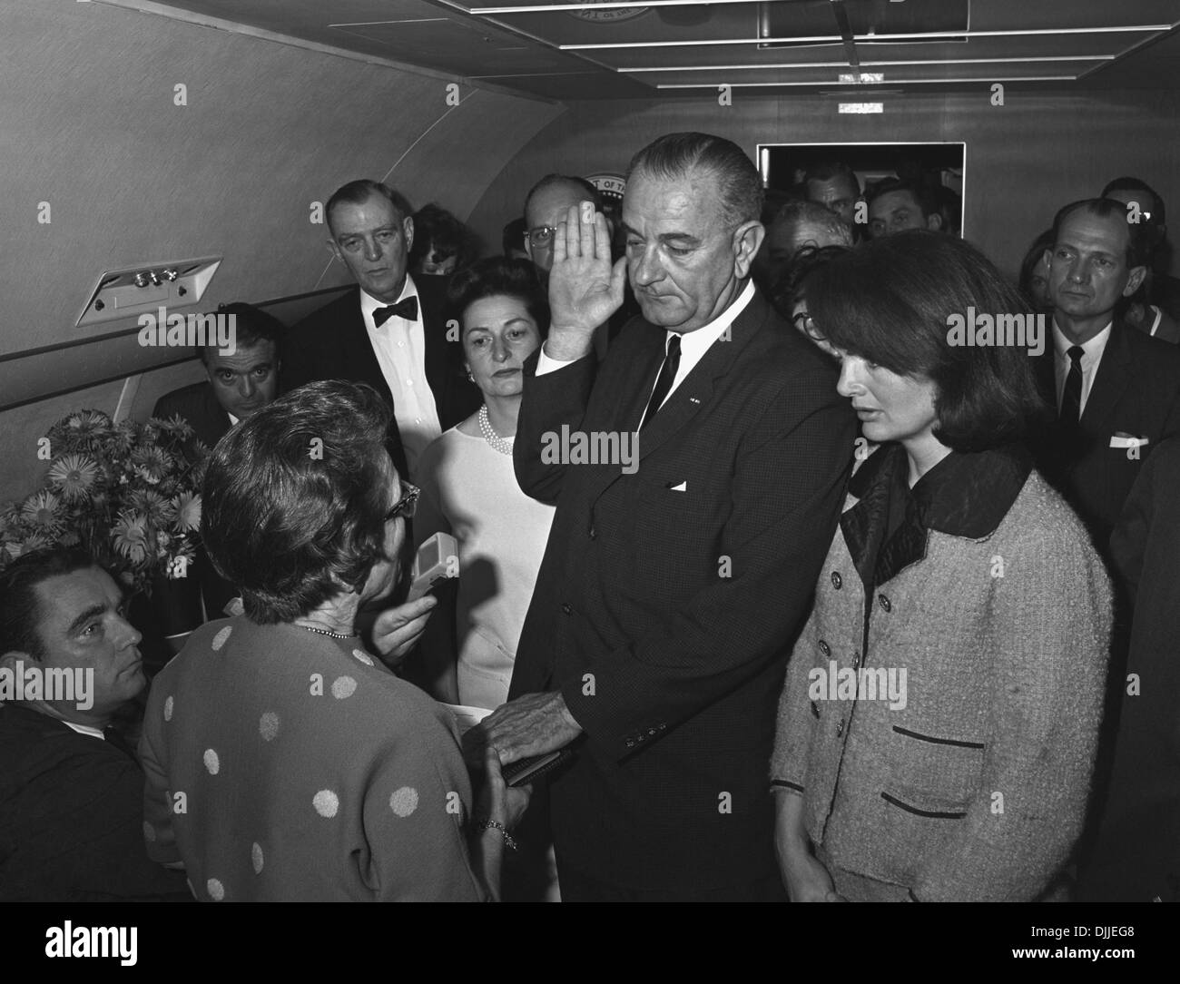 US Vice President Lyndon B. Johnson is sworn in as President by Judge Sarah Hughes following the death of John F. Kennedy onboard Air Force One November 22, 1963 in Dallas, Texas. Attending the event are L-R: Mac Kilduff (lower left corner), Jack Valenti, , Congressman Albert Thomas, Lady Bird Johnson, Chief Jessie Curry (behind LBJ's hand), Jacqueline Kennedy and Congressman Jack Brooks. Stock Photo