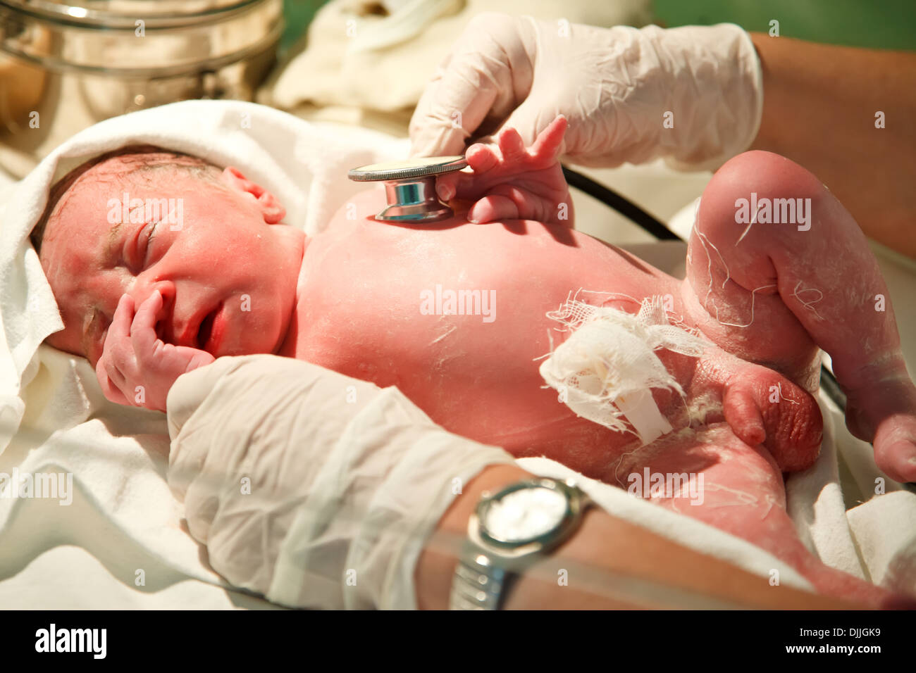 New born baby boy is being examined with a stethoscope after birth in the hospital  Stock Photo