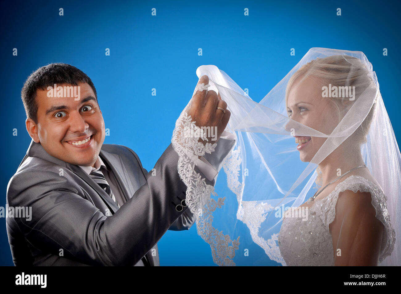 Loving newlyweds standing on a blue background Stock Photo