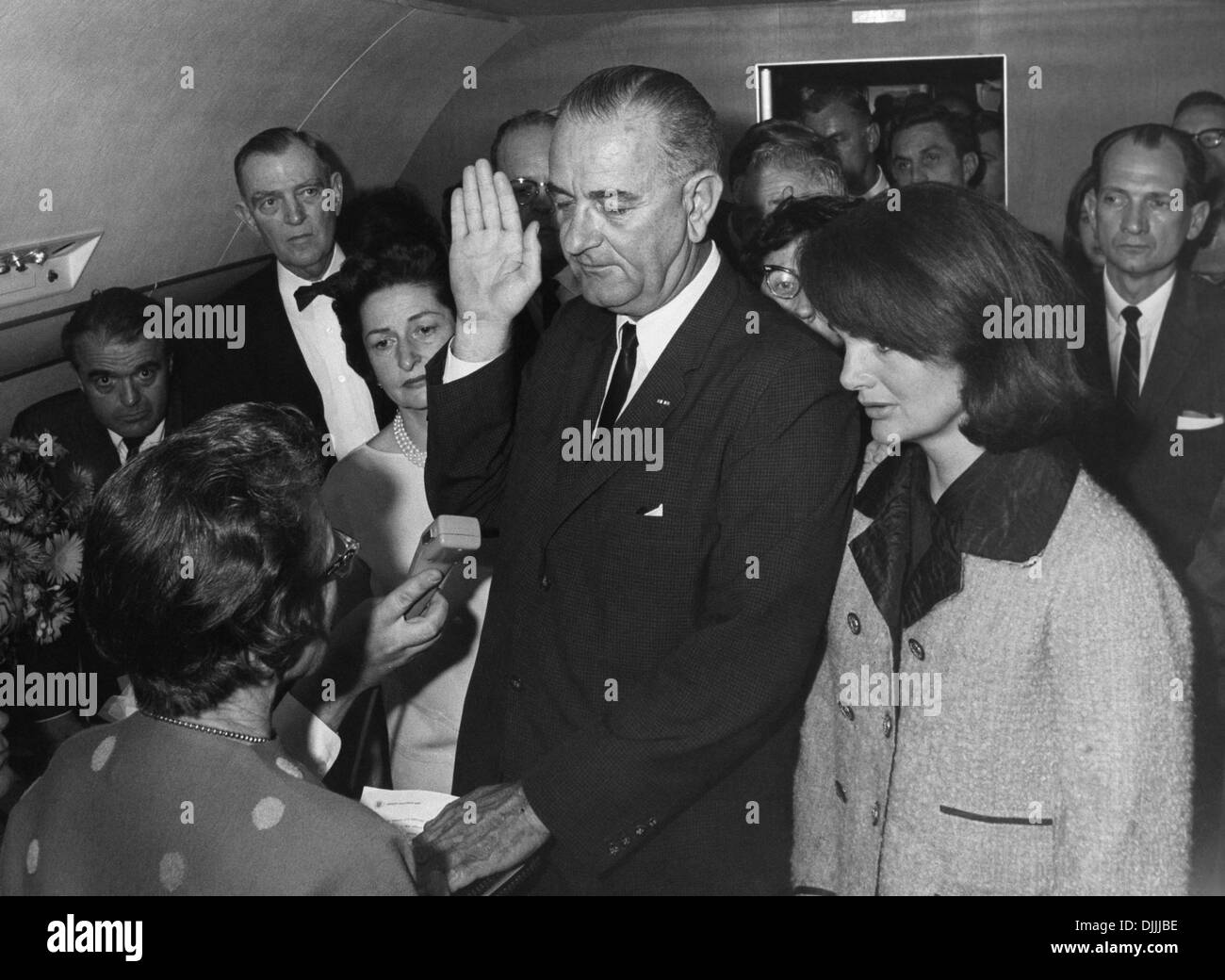 US Vice President Lyndon B. Johnson is sworn in as President by Judge Sarah Hughes following the death of John F. Kennedy onboard Air Force One November 22, 1963 in Dallas, Texas. Attending the event are L-R: Mac Kilduff (lower left corner), Jack Valenti, , Congressman Albert Thomas, Lady Bird Johnson, Chief Jessie Curry (behind LBJ's hand), Jacqueline Kennedy and Congressman Jack Brooks. Stock Photo