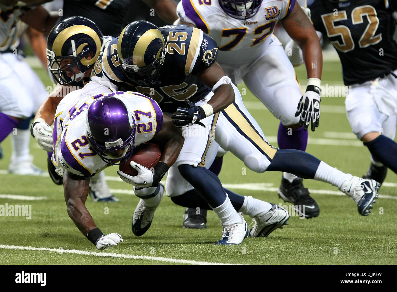 Aug. 14, 2010 - Saint Louis, Missouri, United States of America - August 14, 2010:  Minnesota Vikings Running Back Darius Reynaud (#27) goes gown after being tackled by Saint Louis Rams Free Safety David Roach (#27) and Saint Louis Rams Defensive Back MARQUIS JOHNSON (#25)during a preseason game between the Saint Louis Rams and the Minnesota Vikings held at the Edward Jones Dome in Stock Photo