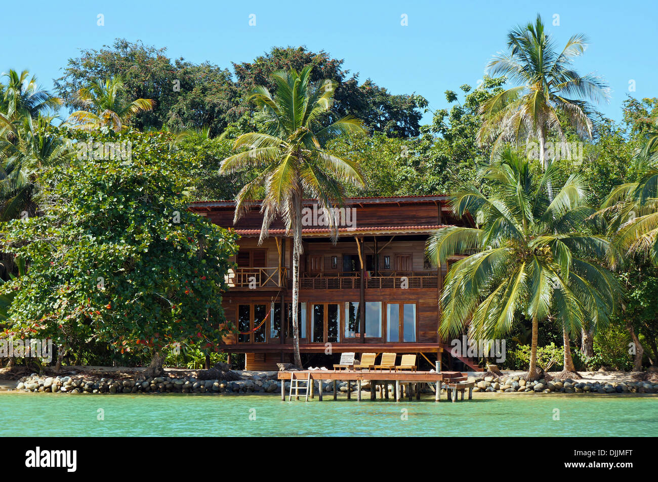 Tropical waterfront beach house with lush vegetation, Caribbean, Bocas del Toro, Panama Stock Photo