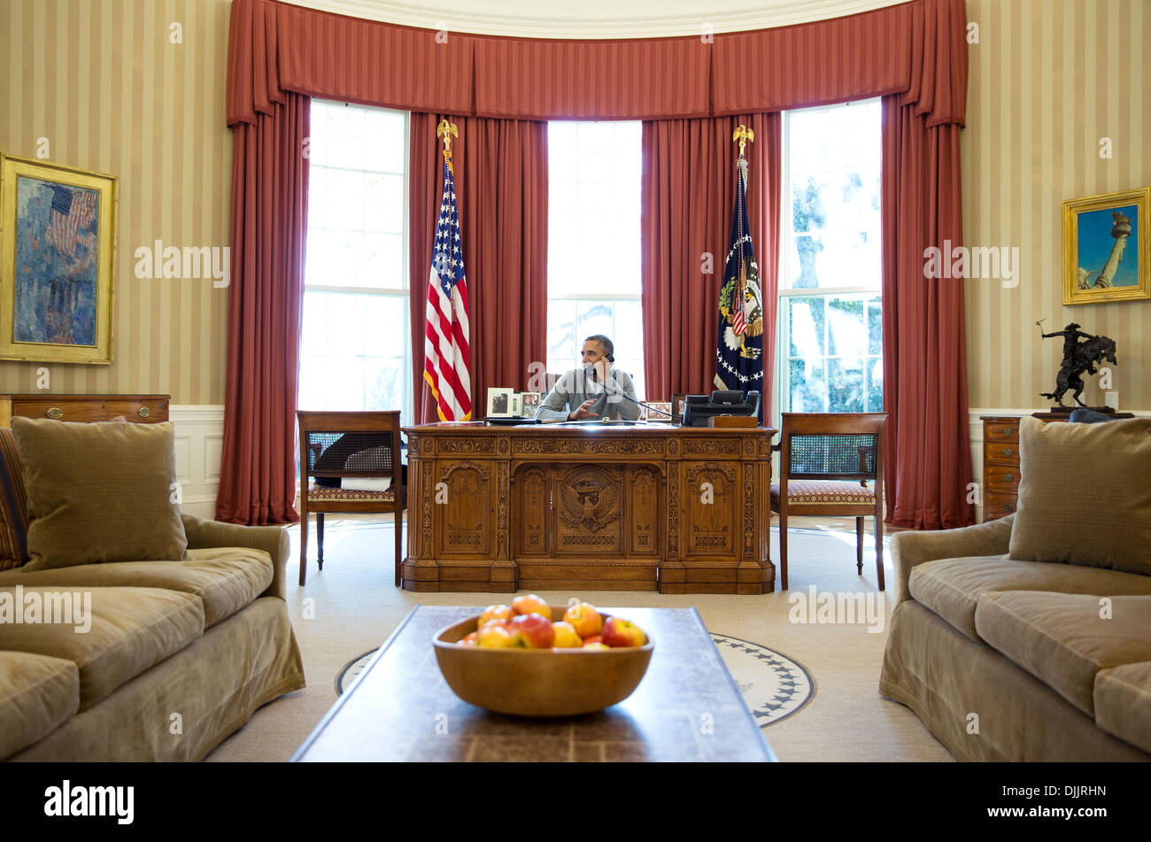 US President Barack Obama makes Thanksgiving Day phone calls to U.S. troops from the Oval Office of the White House November 28, 2013 in Washington, DC. Stock Photo