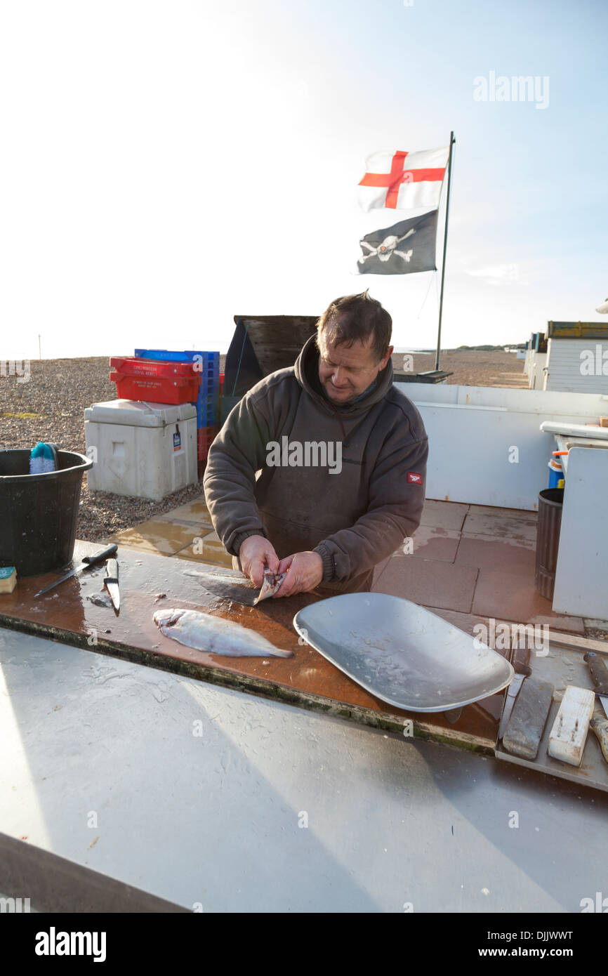 Fisherman prepares some freshly caught flatfish for a customer on the ...