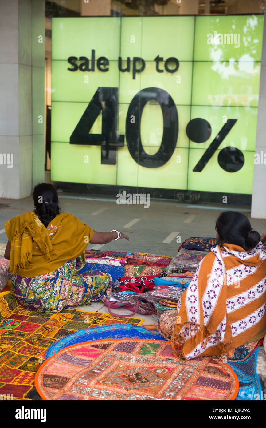 Two women have a small hawker stall in front of a famous clothing store in Connaught Place. Stock Photo