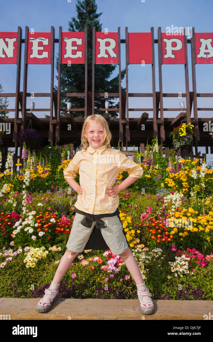 5 Year Old Caucasian Girl Standing In Front Of The Entrance To Pioneer Park Amusement Park, Summer, Fairbanks, Interior Alaska Stock Photo