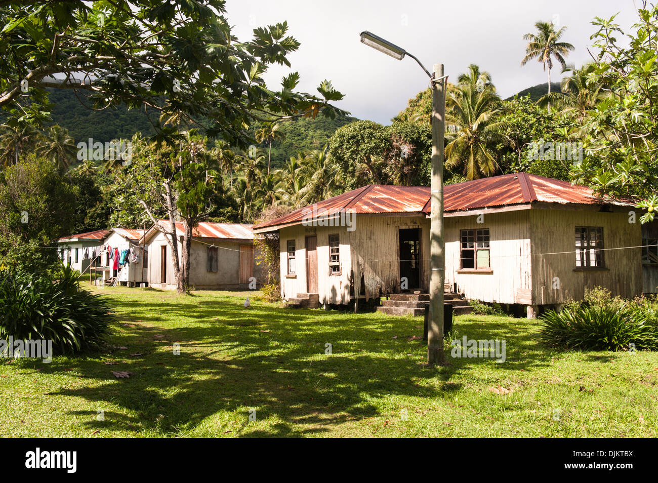 Rusting corrugated roofs on houses, the nearest unoccupied and seemingly untended, a consequence of rural depopulation in Fiji Stock Photo
