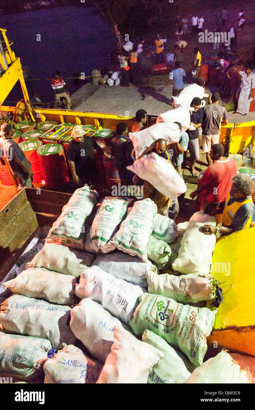 Loadings sacks of copra onto Lady Sandy supply boat, berthed alongside the wharf near Ketei and Tovu. Totoya, Lau Islands Fiji Stock Photo