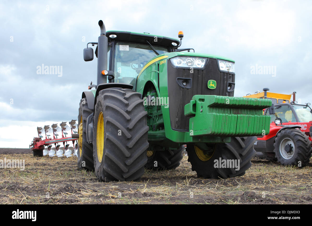 John Deere tractor with a plow preparatory to plowing in autumn field ...