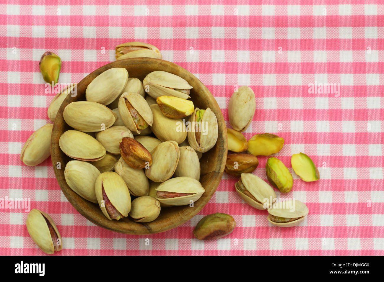 https://c8.alamy.com/comp/DJMGG0/pistachio-nuts-in-wooden-bowl-on-pink-checkered-cloth-with-copy-space-DJMGG0.jpg