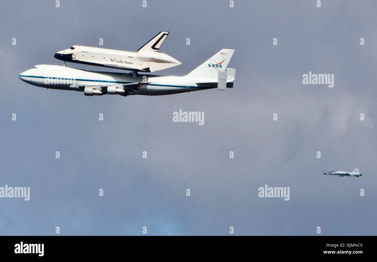The space shuttle Enterprise flies over New York City strapped on a