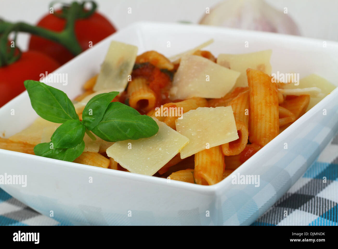 Pasta with tomato sauce, grana padano cheese and fresh basil Stock Photo