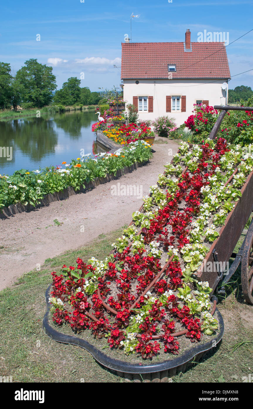 Floral display adjacent to lock on the Canal du Centre Burgundy eastern France Stock Photo
