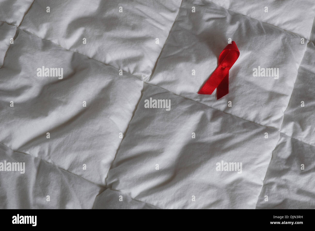 Illustration - an illustrated picture shows an AIDS-loop lying on a bed ...
