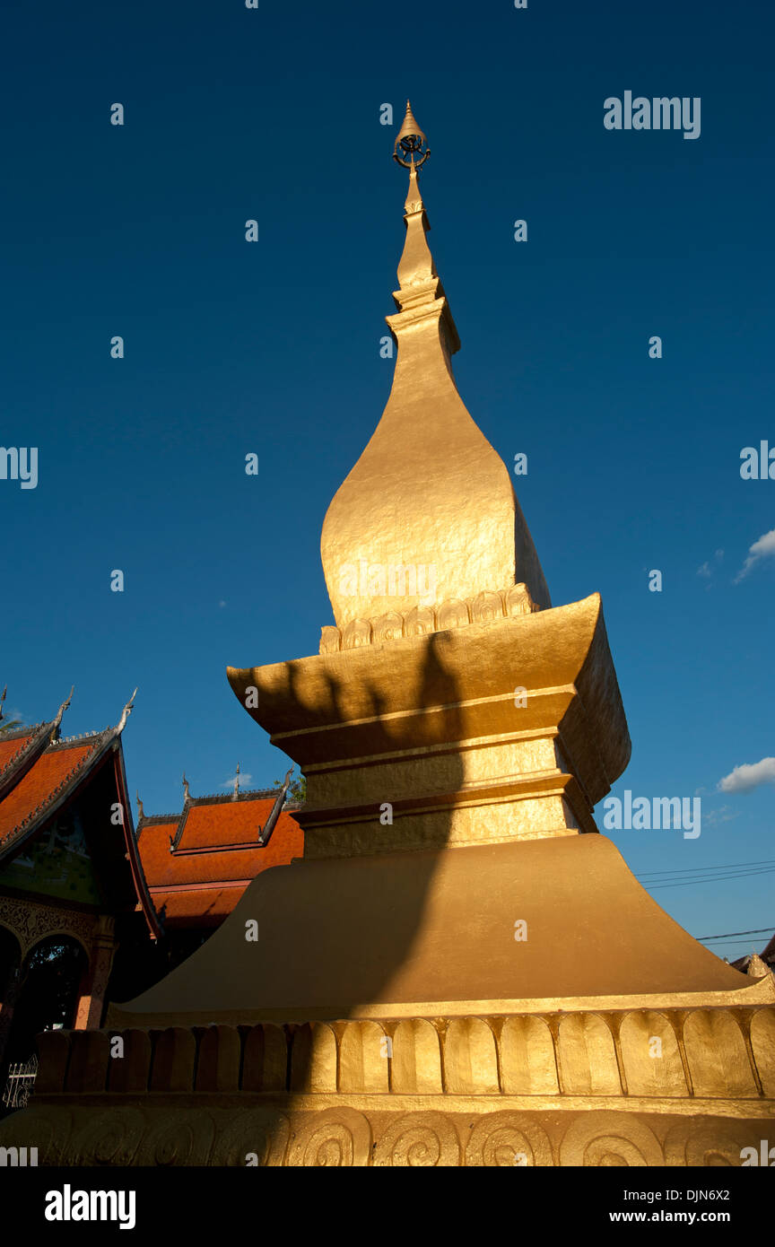 A golden spire of Wat Saen Temple Luang Prabang Laos against a dark blue sky Stock Photo