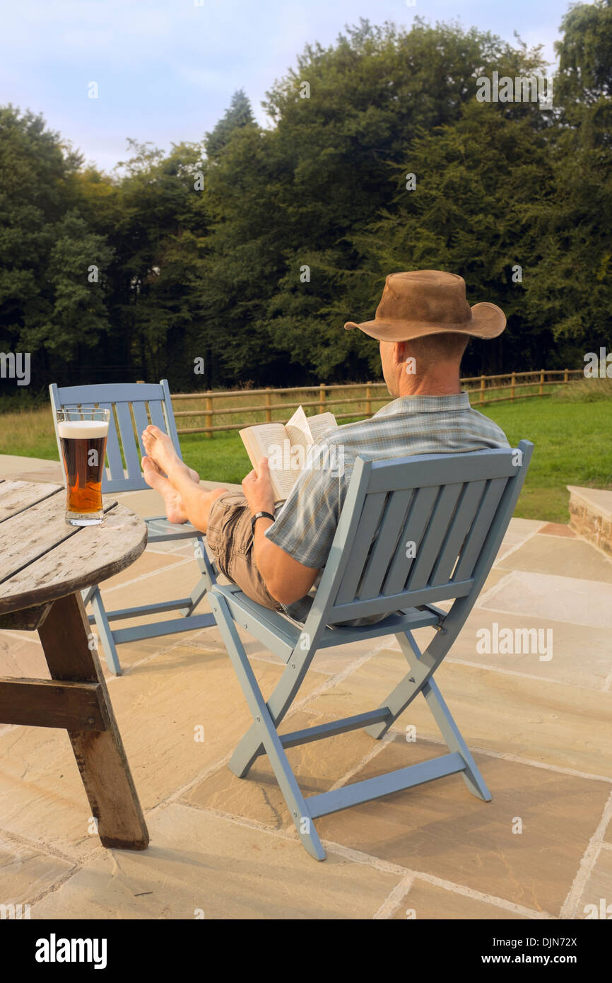 A man relaxing with a book and glass of beer. Stock Photo