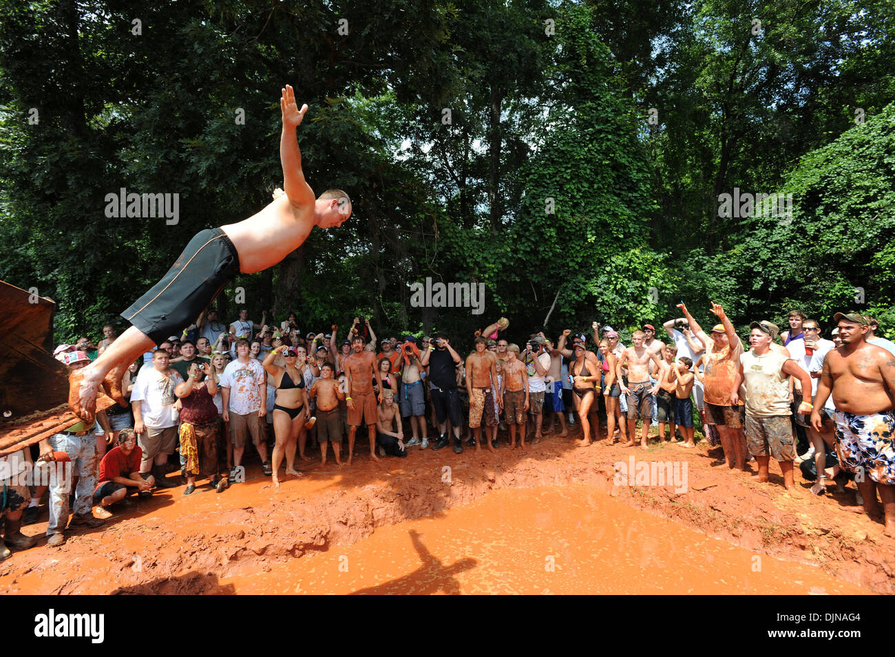 Mar 11, 2008 - East Dublin, Georgia, USA - Jeremiah Hatfield jumps in from a backhoe during the Mudpit Belly Flop event during the 13th annual Summer Redneck Games at Buckeye Park in East Dublin, Georgia, on Saturday. The annual homage to Southerners, began as a spoof to the 1996 Summer Olympics in Atlanta. Thousands of revelers attend the event whose events include bobbing for pig Stock Photo