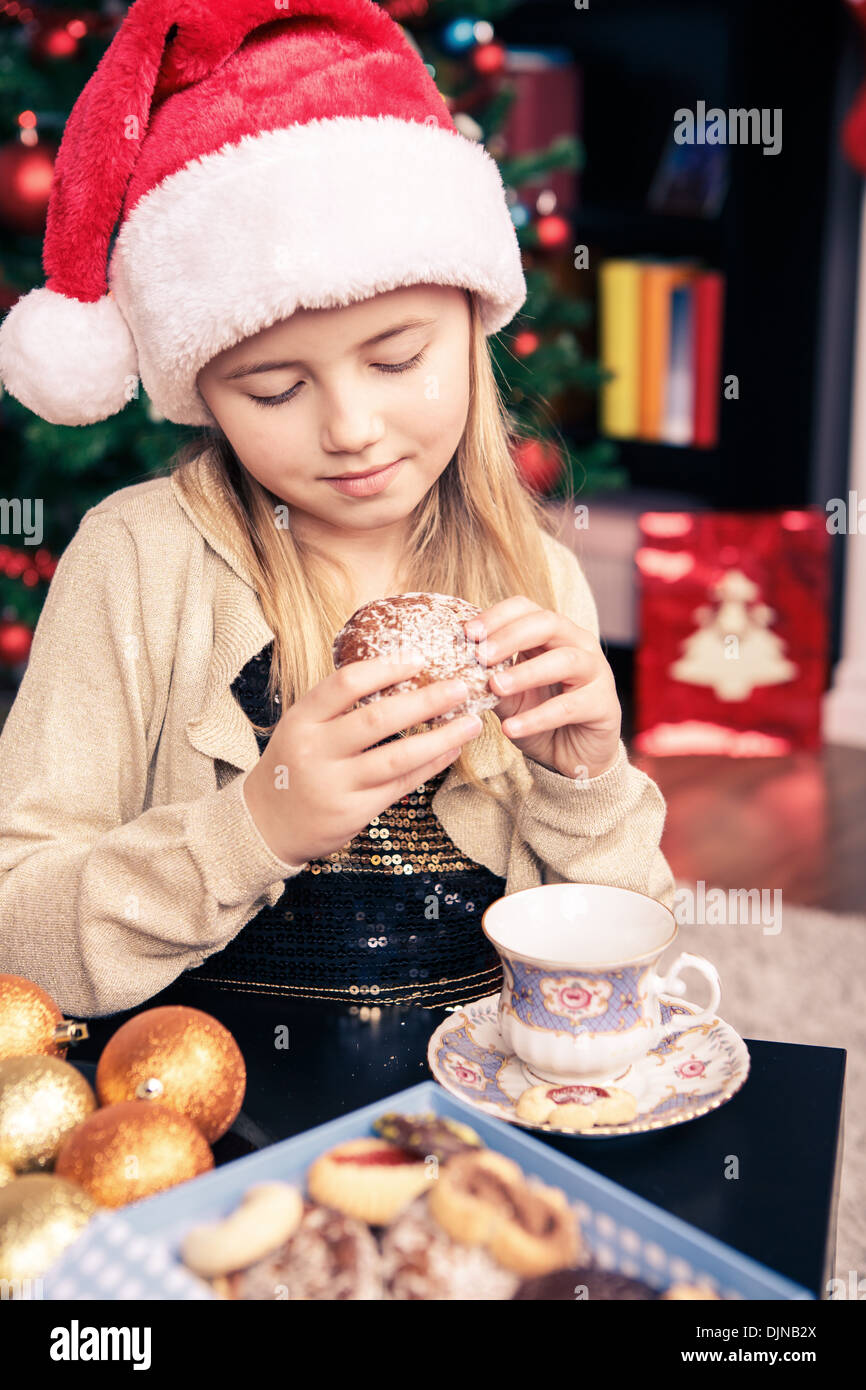 little girl eating xmas cookies at home Stock Photo
