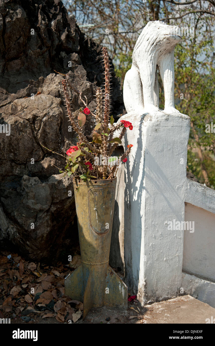 Tail fin bomb case made into a plant pot in the grounds of a temple in Laos Stock Photo