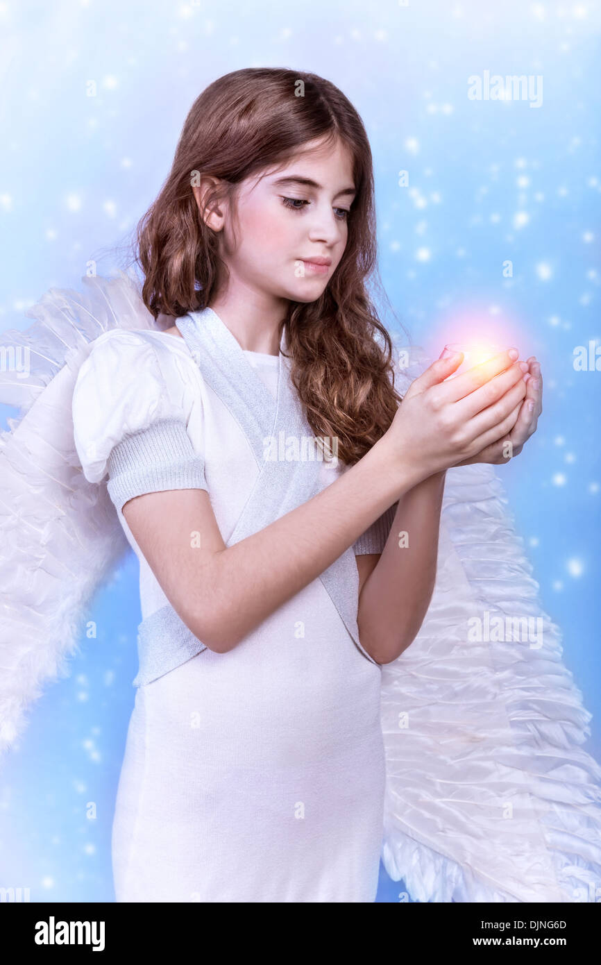 Cute Christmas angel on blue snowy background, adorable girl with