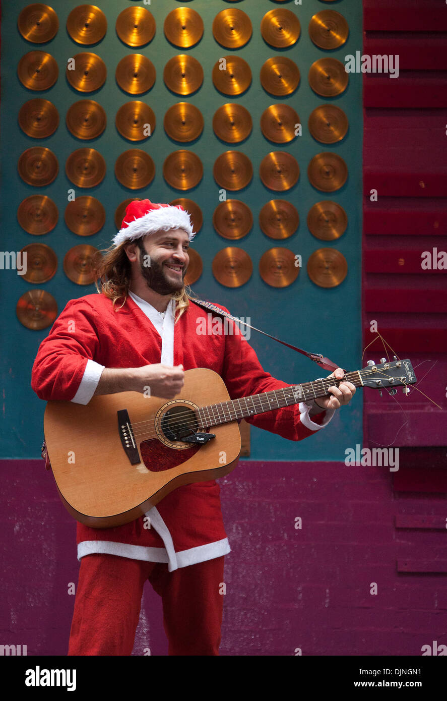 Liverpool, Merseyside, UK 29th November, 2013. Father Christmas busker Robert Bethea, 32  from Spain busking. Liverpool One  city centre holiday shopping season, retail shops, stores, Christmas shoppers, discount sale shopping, and consumer spending on Black Friday considered to be the biggest shopping day of the year.   U.K. retailers have embraced the U.S. post-holiday sale bonanza, even though many customers were left surprised by wall-to-wall discounts in their favourite stores as some went bonkers for bargains. Stock Photo