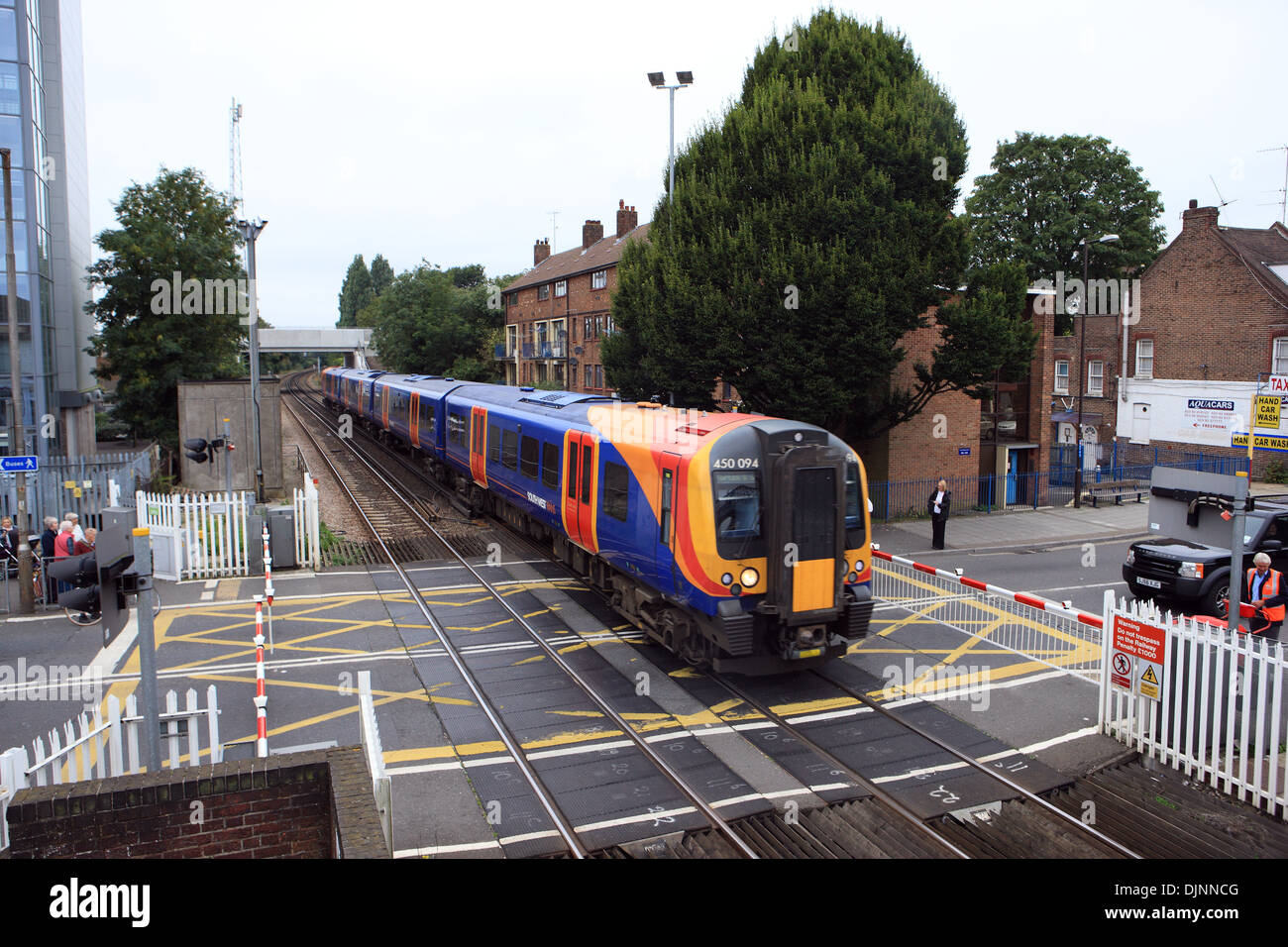 Barriers down as a train crosses a level crossing in Cosham near Portsmouth, England Stock Photo
