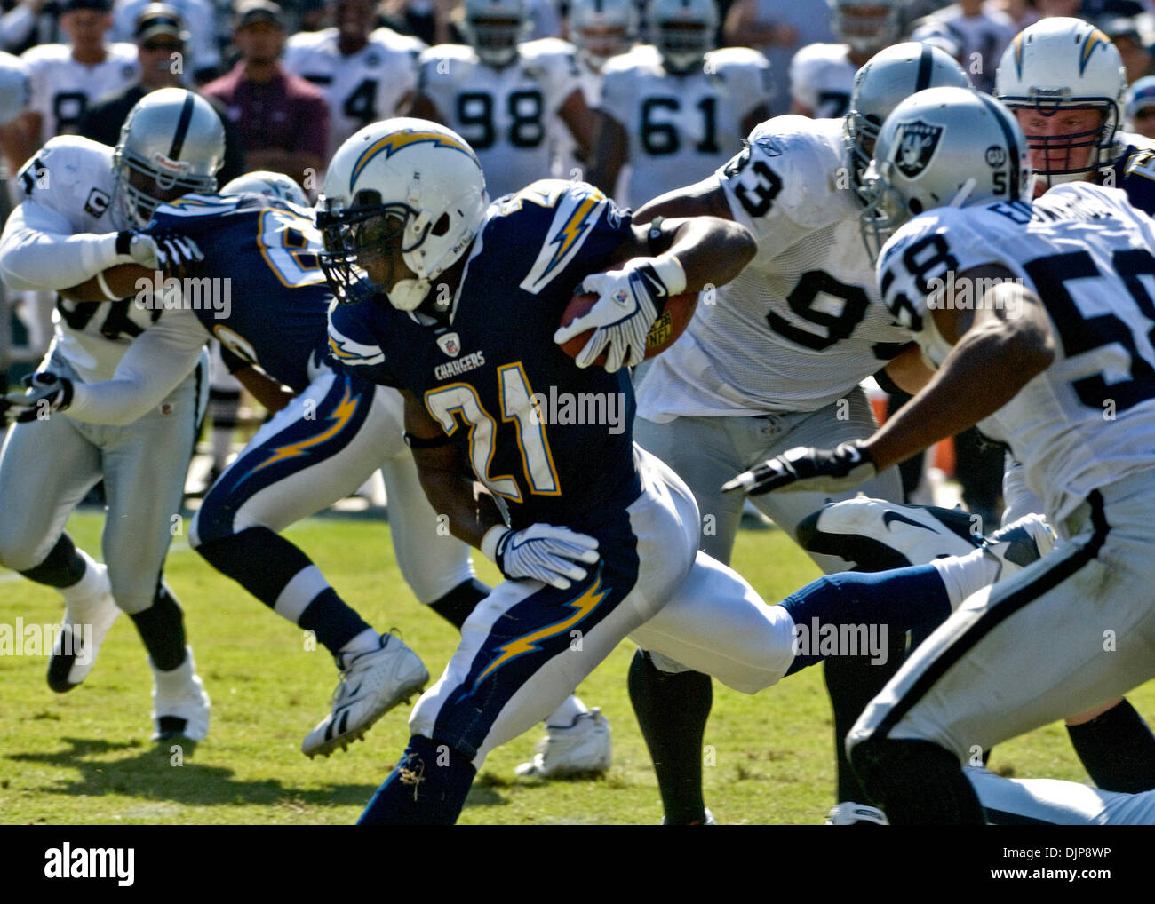 Sep 28, 2008 - OAKLAND, CA, USA - San Diego Chargers running back LADAINIAN TOMLINSON #21 runs between Oakland Raiders defensive tackle TOMMY KELLY #93 and defensive end KALIMBA EDWARDS #58 during a game at McAfee Coliseum. (Credit Image: © AL GOLUB/Golub Photography/Golub Photography) Stock Photo