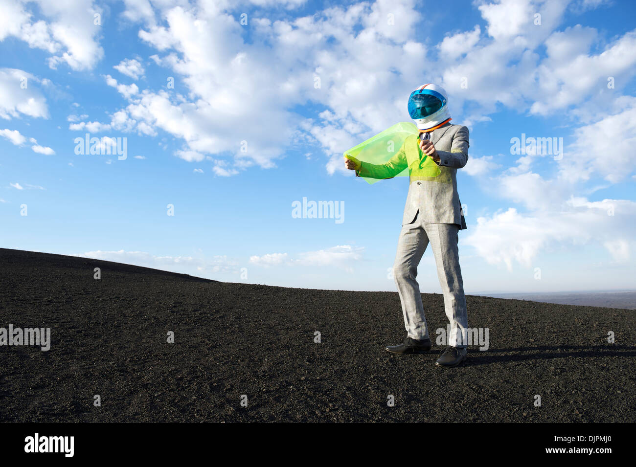 Explorer businessman in lunar landscape reads electronic map on future technology flexible display tablet Stock Photo