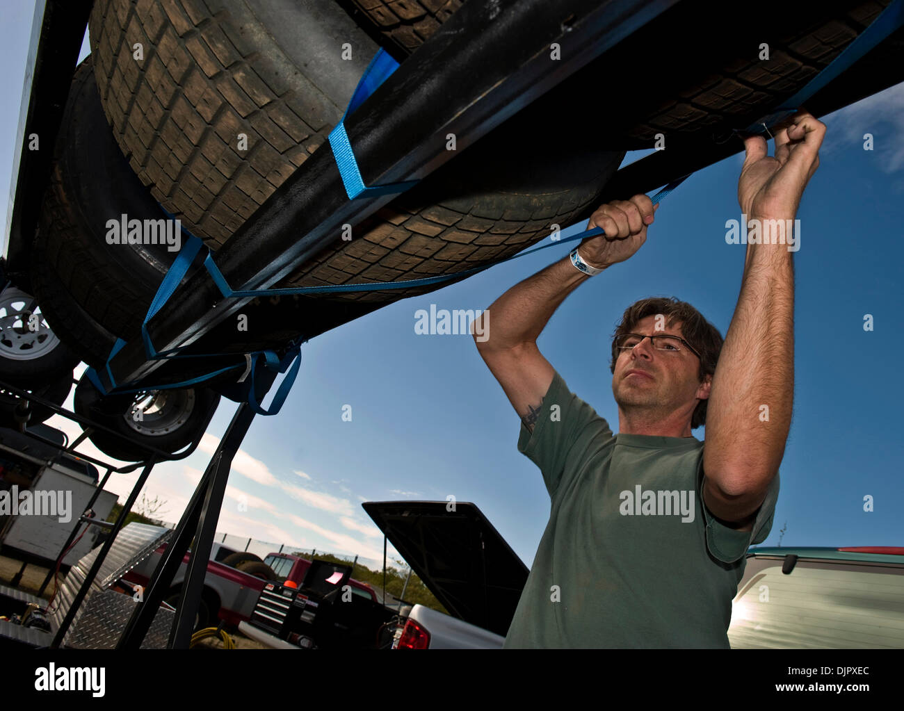 Apr 24, 2010 - New Egypt, New Jersey, USA -  DONNY ANDREAS, from Langhorne, PA, makes certain the tire he just swapped out is secured on his trailer in the pits of the 3/8 mile, red clay New Egypt Speedway, the site of short track car racing since the 1950's.  In this small New Jersey town which borders the Jersey pine barrens, the racing season runs from April through October.  On Stock Photo