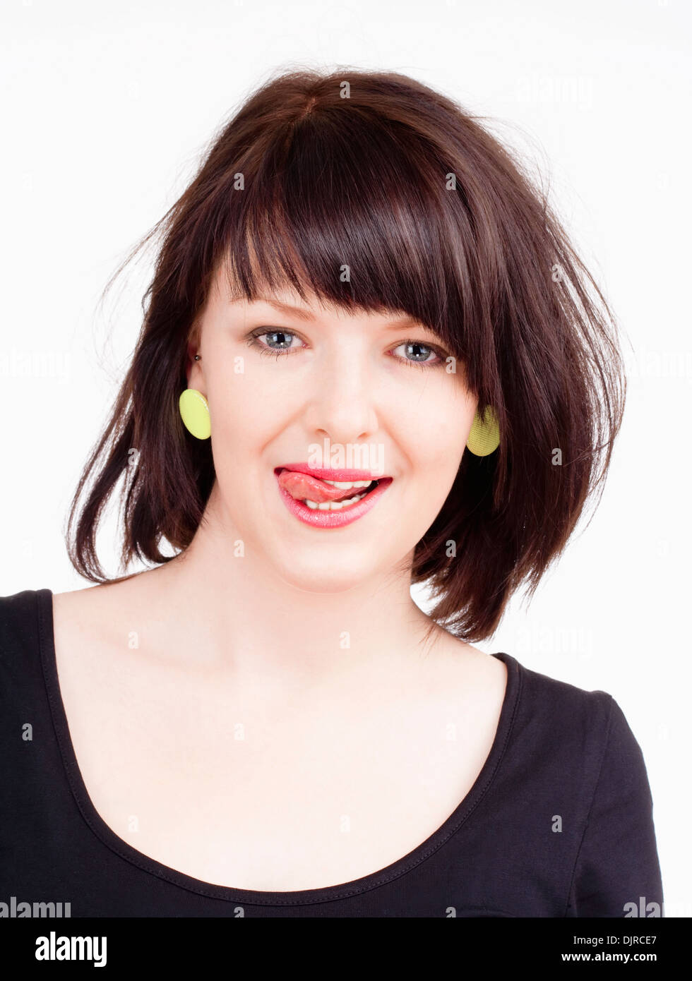 Young Woman with Dark Brown Hair Licking her Lips Stock Photo