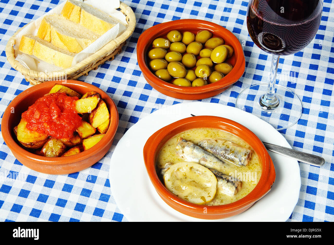 Spanish tapas selection of sardines in lemon sauce, patatas bravas