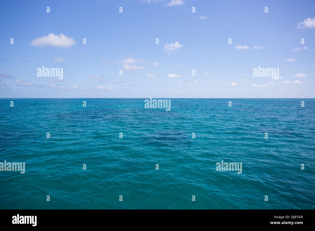View of the Coral Sea on a sunny day with clouds in the sky, off the coast of tropical north Queensland, Australia Stock Photo