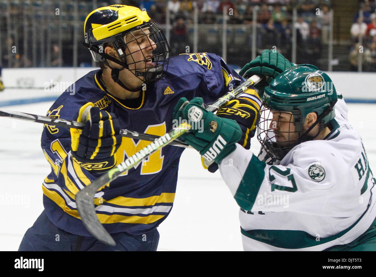 Michigan forward Kevin Lynch (11) and Bemidji State defenseman Kyle Hardwick  (27) battle for position in from of the net during game action. Michigan  defeated Bemidji State 5-1 in the NCAA Division