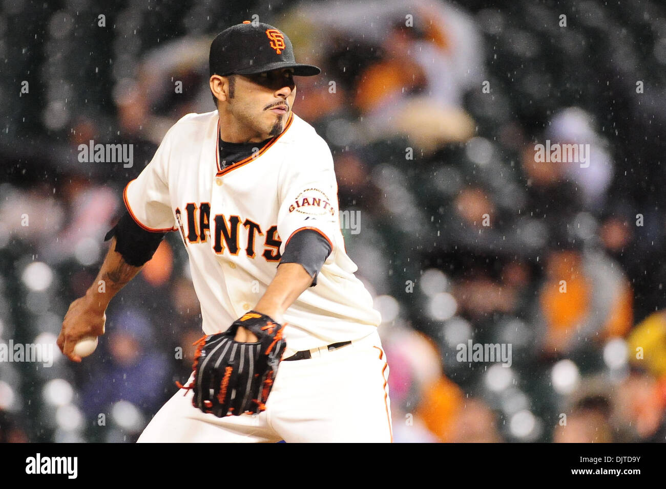 San Francisco, CA: San Francisco Giants pitcher Sergio Romo (54) pitches as  rain falls at AT&T park during the game against the Washington Nationals.  The Giants won the game 4-2. (Credit Image: ©