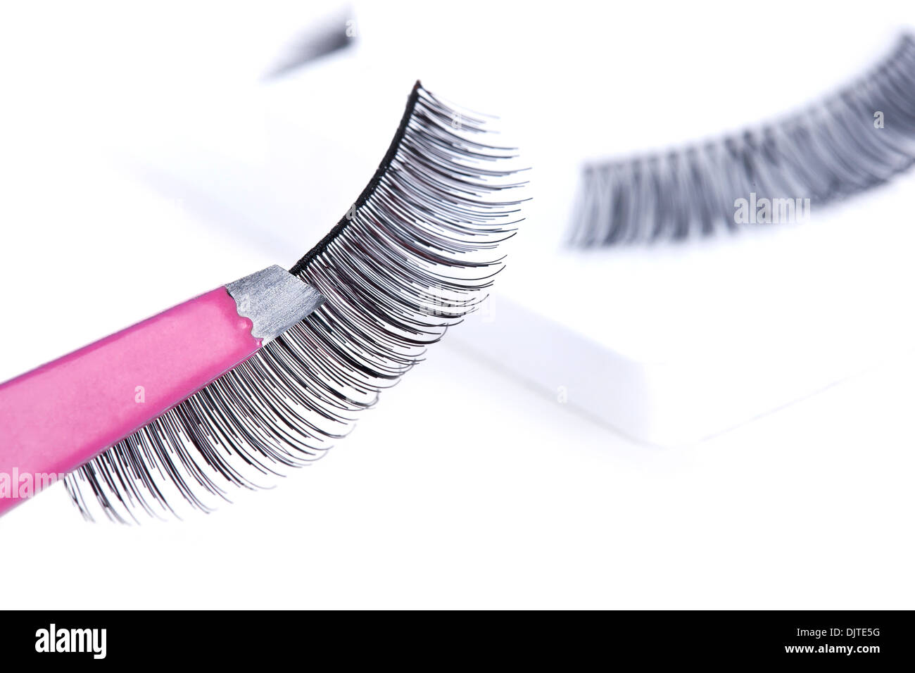 False lashes and pink pincers, closeup on white background  Stock Photo