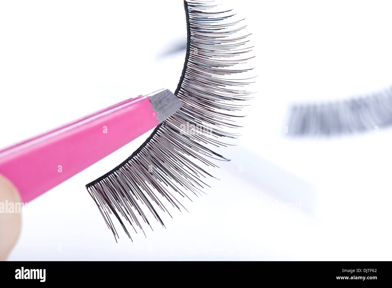 False lashes and pink pincers, closeup on white background  Stock Photo