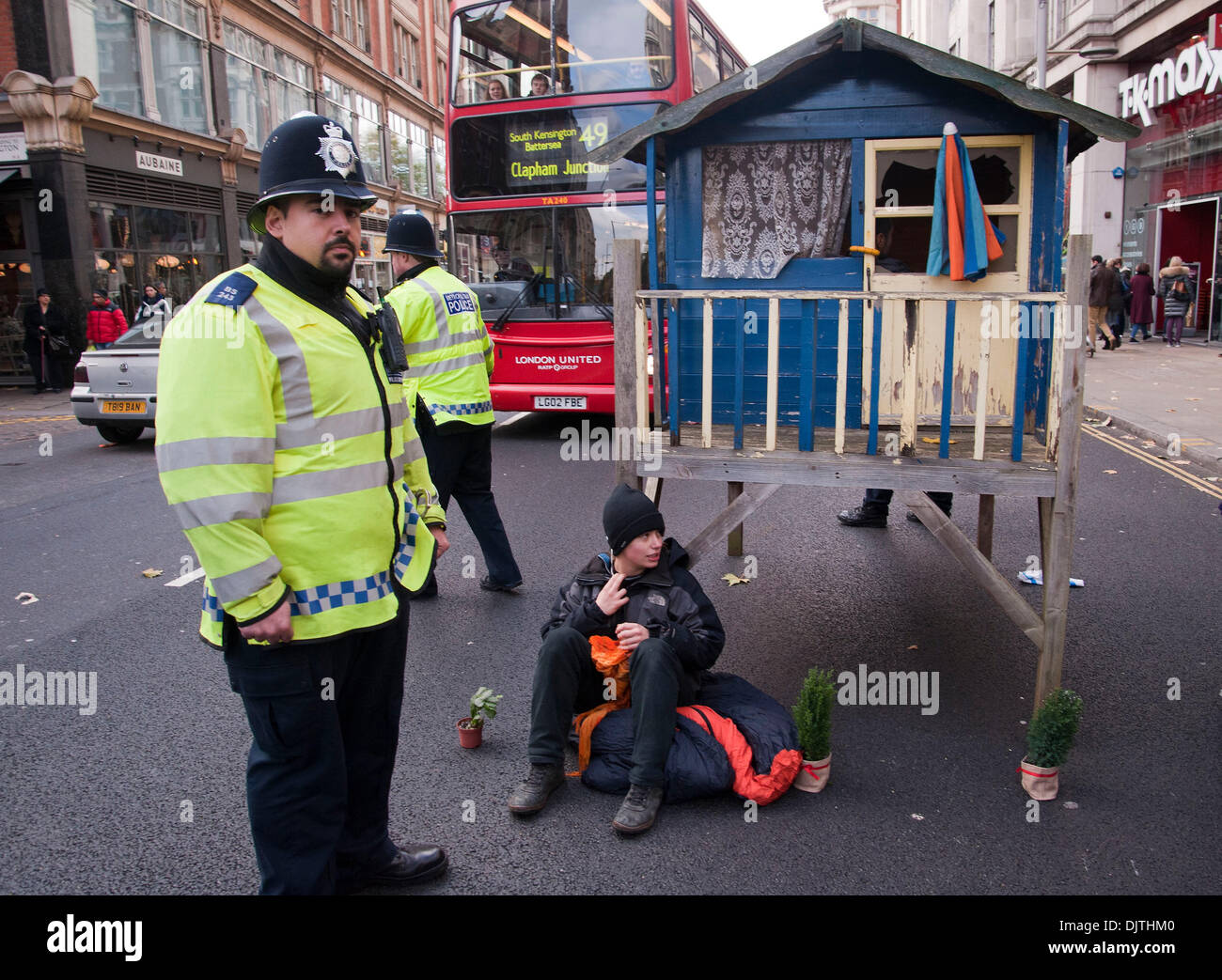 London, UK. 30th November 2013.Protesters against the proposed Israeli Prawer Plan block the road outside the Israeli Embassy with a small wooden house.Activists have 'locked on' to the structure with bike locks around their necks. The protesters claim that the Israeli government plans to displace 70, 000 Bedouin Palestinains to make room for Israeli settlements. Credit:  Pete Maclaine/Alamy Live News Stock Photo