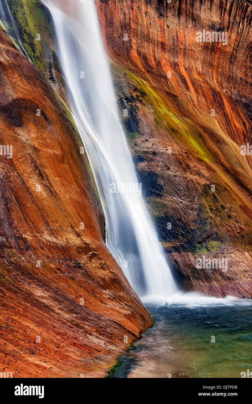 Lower Calf Creek Falls pours over the brilliant colored walls of Navajo sandstone in Utah's Escalante National Monument. Stock Photo