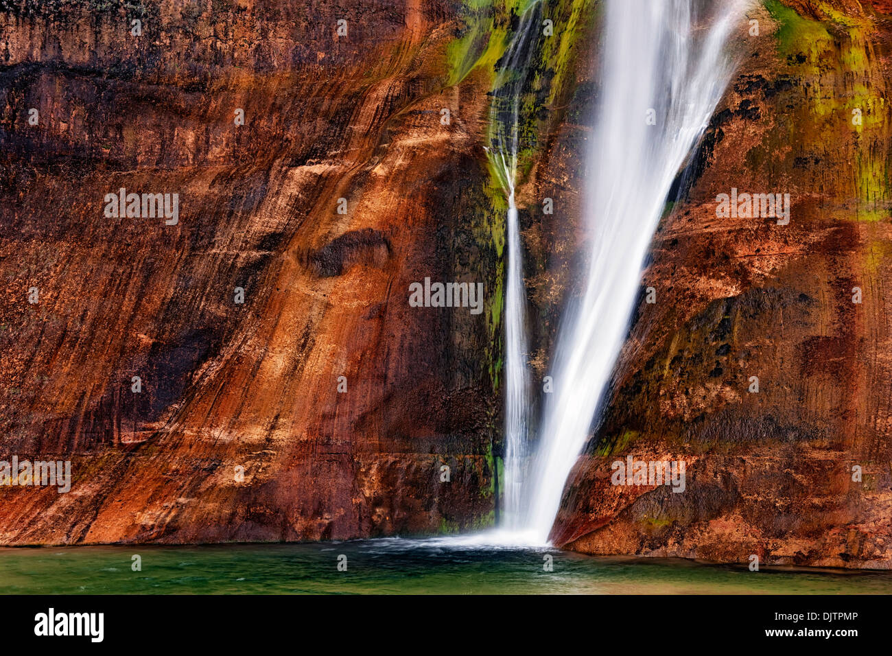 Lower calf Creek falls pours over the brilliant colored walls of Navajo Sandstone in Utah's Escalante National Monument. Stock Photo