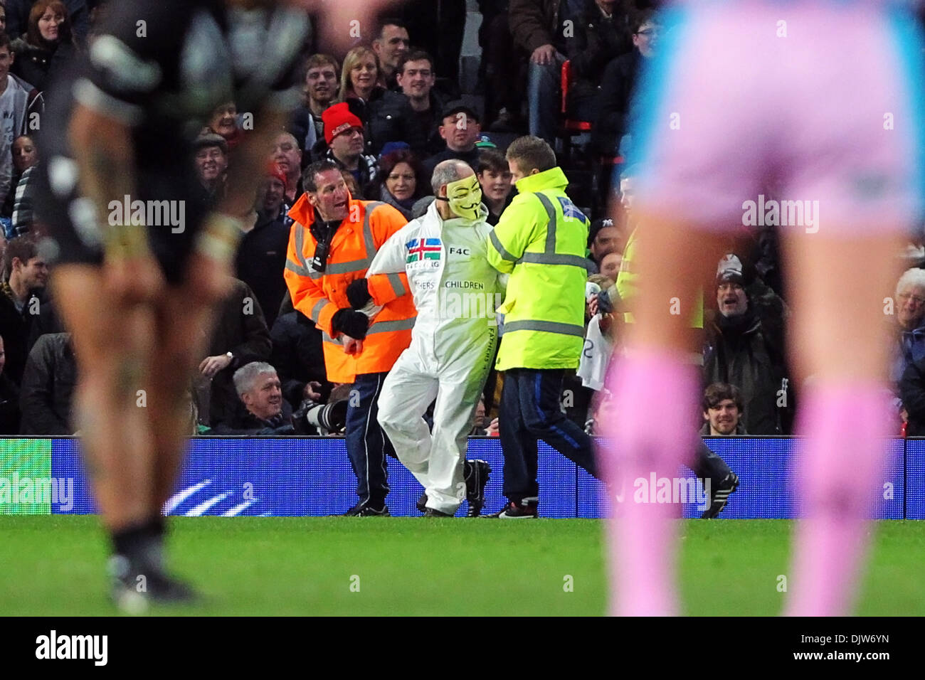Manchester, UK. 30th Nov, 2013. A Fathers For Action Protestor runs on to the pitch and is escorted from the stadium during the Rugby League World Cup Final between New Zealand and Australia at Old Trafford Manchester. Credit:  Action Plus Sports/Alamy Live News Stock Photo