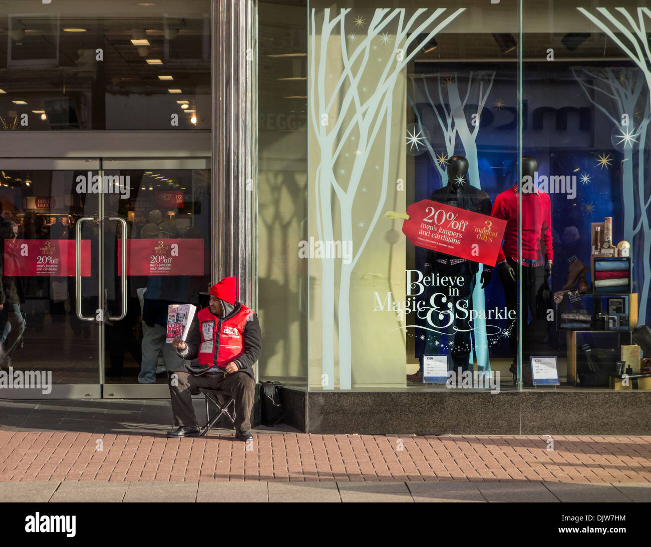 Big issue seller outside a department store.Optimistic, pessimistic. Stock Photo