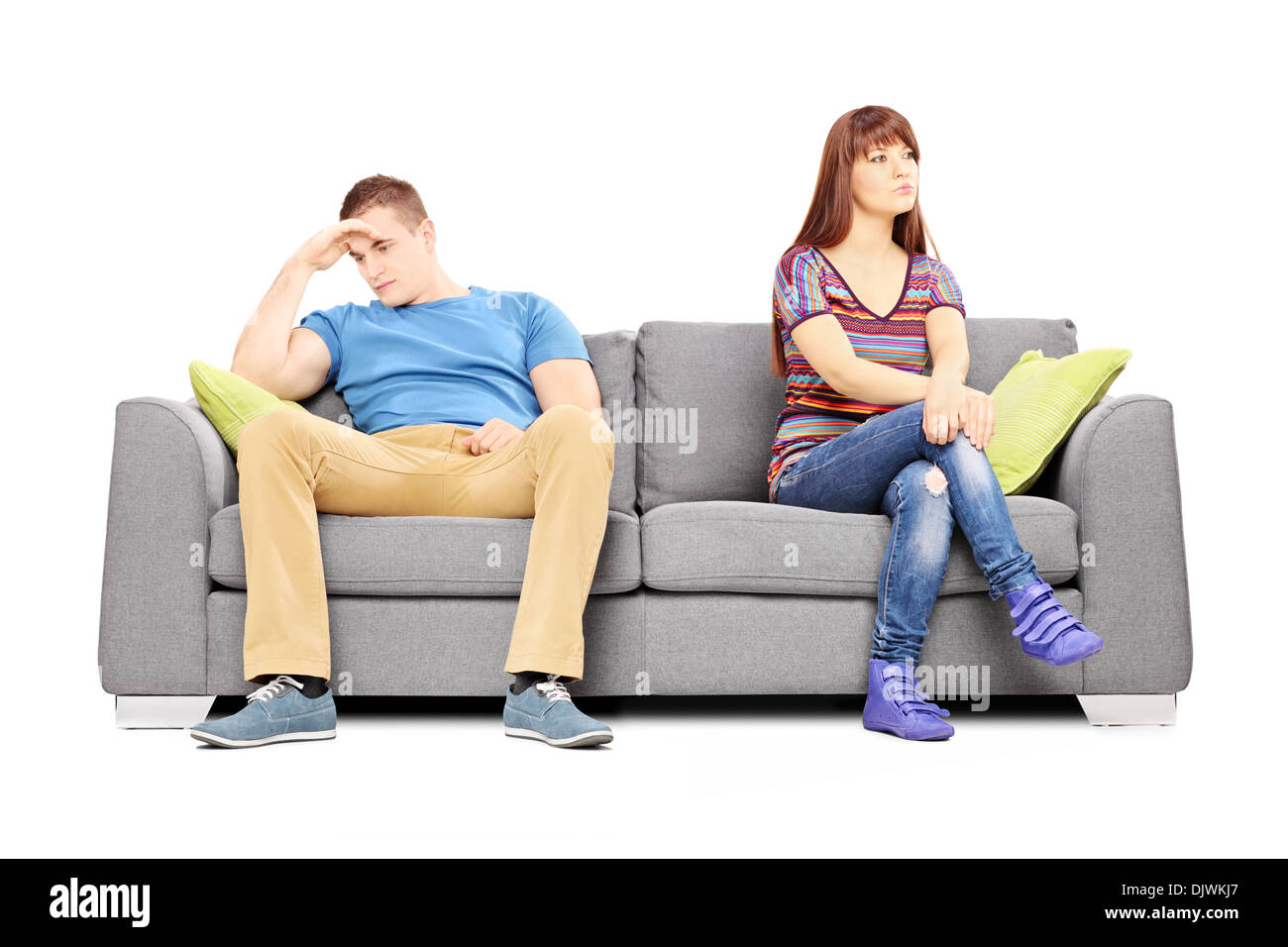 Sad heterosexual couple sitting on a sofa after an argument Stock Photo