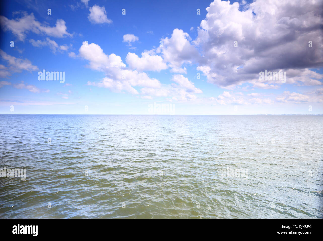 White fluffy clouds blue sky above a surface of the sea Stock Photo - Alamy