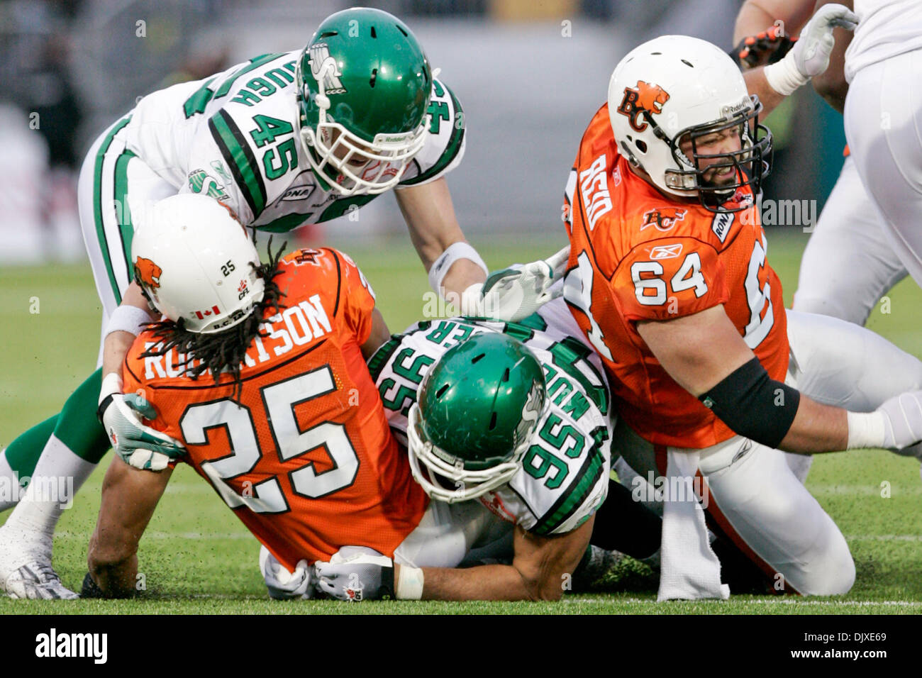 Oct. 31, 2010 - Vancouver, British Columbia, Canada - Lions #25 RB Jamal Robertson gets tackled by Roughriders #95 DE Luc Mullinder and #45 LB Mike McCullough during the sunday game at Empire field BC Lions won the game with a score of 23 to 17 against the Saskatchewan Roughriders for their last home game of the season (Credit Image: © James Healey/Southcreek Global/ZUMApress.com) Stock Photo