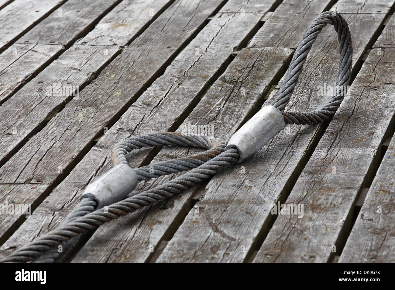 Mooring equipment on wooden pier. Steel rope Stock Photo