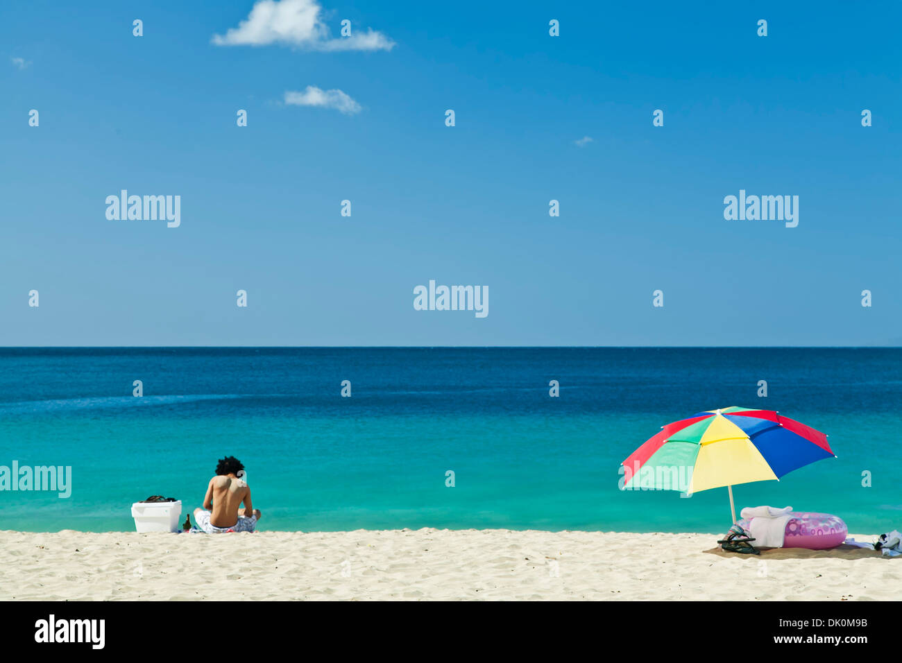 Man and colorful beach umbrella, Crashboat Beach, Aguadilla, Puerto Rico Stock Photo