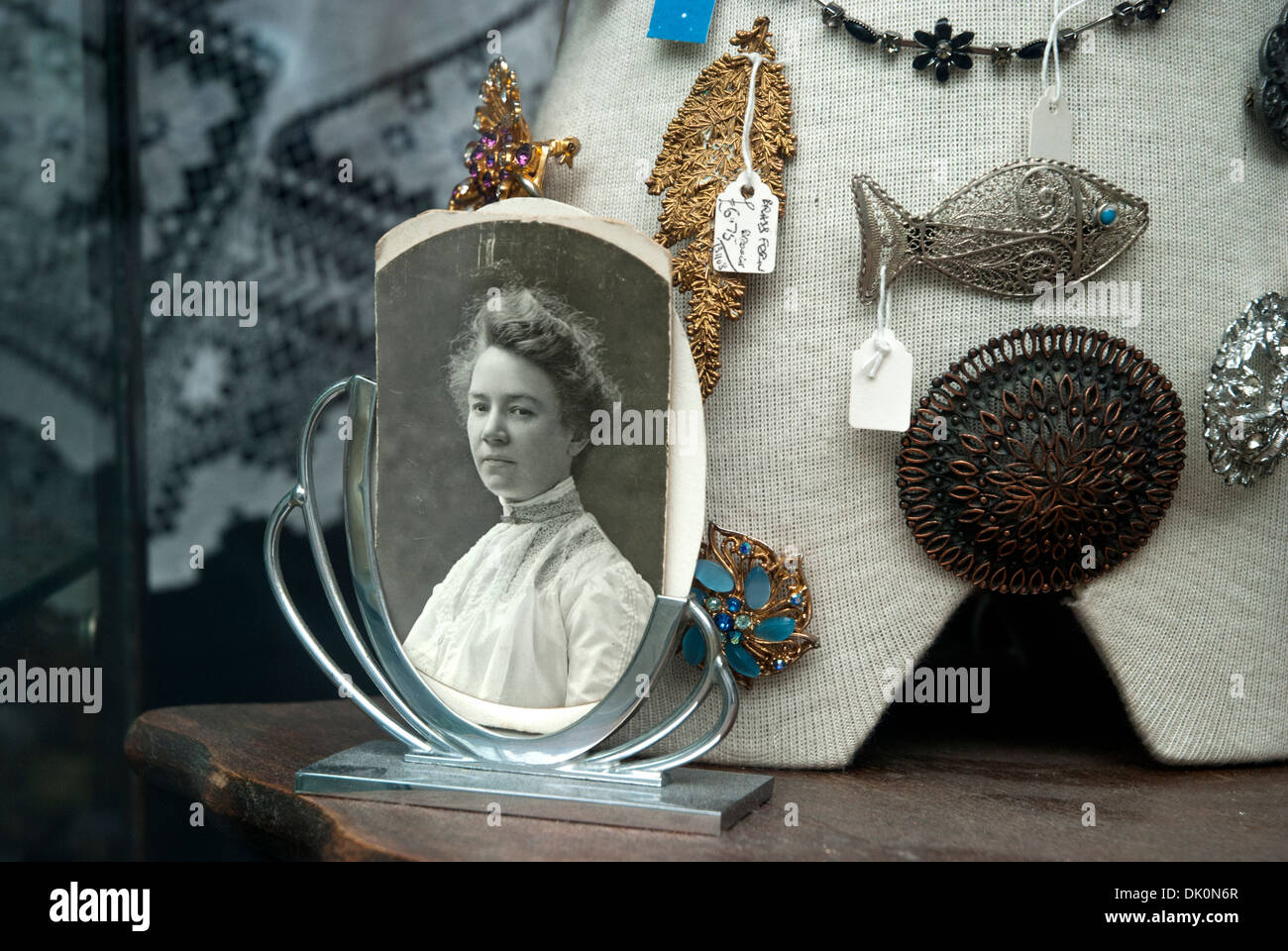 Black and white photograph of a Victorian woman on display in an antique/junk shop window. Stock Photo