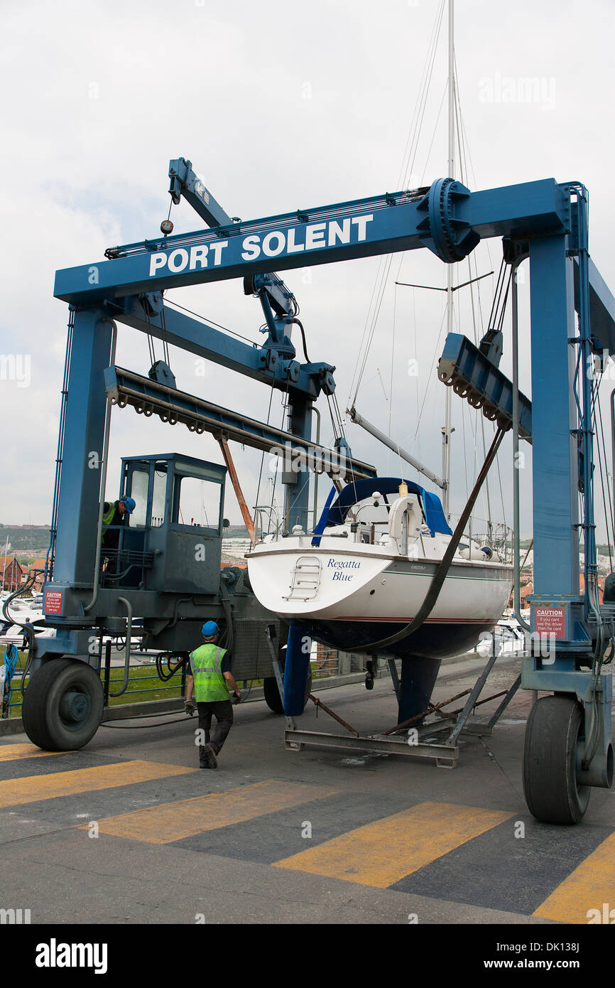 A Boat crane at Port Solent moves a small keel boat "Regatta Blue Stock