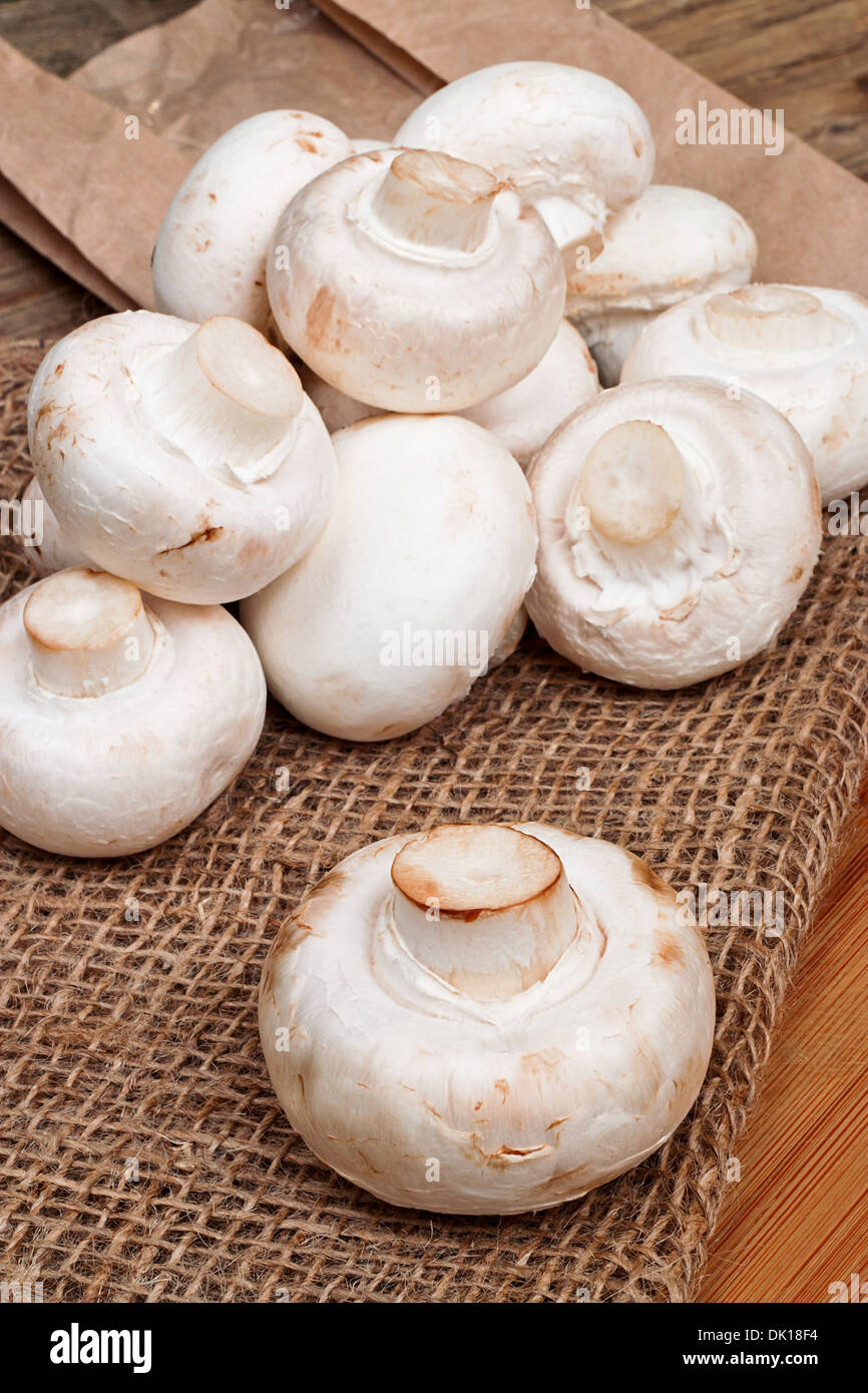 Fresh closed cup button mushrooms on a rustic kitchen worktop Stock Photo