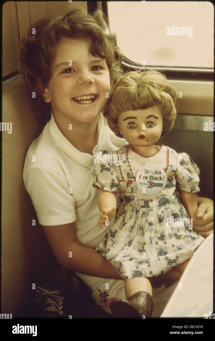 YOUNG GIRL SHOWS OFF HER DOLL ON THE SOUTHWEST LIMITED WHICH SPORTS A PIN PROCLAIMING TRACKS ARE BACK IT AND... 555979 Stock Photo